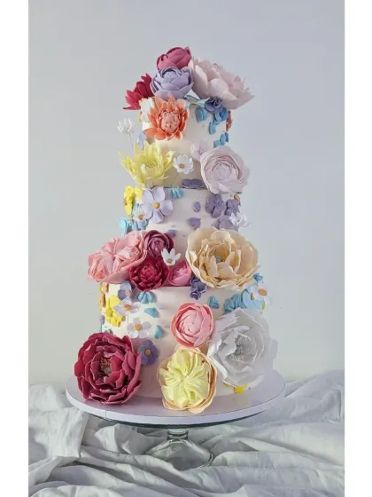 For this wedding cake, I wanted to create the feeling of a spring garden in full bloom. It’s covered in a mix of handcrafted sugar flowers and delicate buttercream flowers, making it a joyful and spectacular centerpiece for a truly special day.
