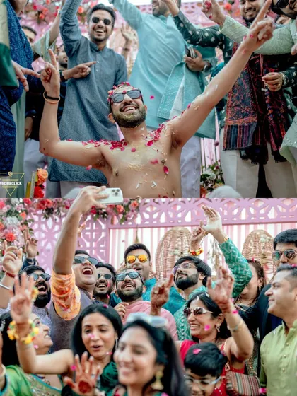 The wild energy of a Haldi celebration! Friends and family dancing, celebrating, and showering the groom with petals in a moment of pure, uninhibited fun.