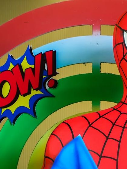 A close-up of a life-sized Spiderman figure with a "POW!" cutout, showcasing the high-quality props we use to create an authentic superhero atmosphere.