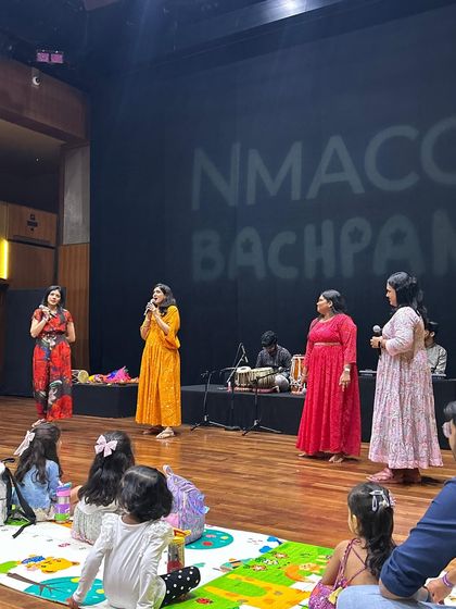On stage at NMACC Bachpan, we are joined by our team of musicians to present a rich tapestry of Indian folk music. The children are seated on mats, ready for an immersive session of sound and culture.