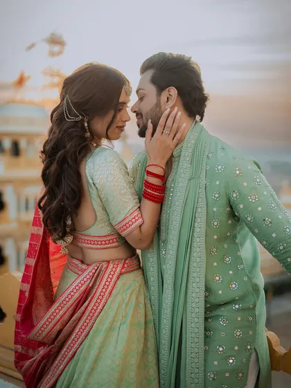 An intimate couple portrait from their Mehendi event, set against the backdrop of a heritage location at sunset.