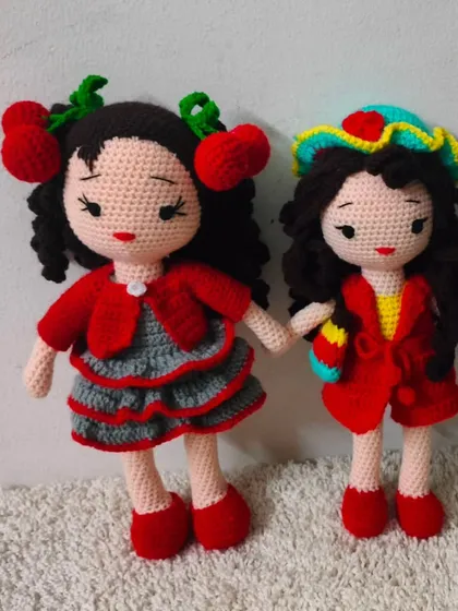 Two very stylish dolls. One has cherry clips in her curly hair, and the other is ready for the beach with her colorful hat.