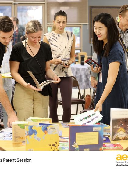 Parents browse books and resources at the literacy station during the Grade 1 workshop. We aim to provide practical tools to support learning at home.