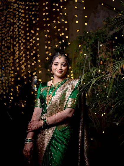 An elegant portrait of the bride standing amidst twinkling lights, looking serene and happy.