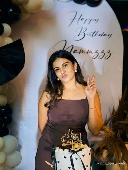 A chic black and white theme for actress Namratha Gowda's birthday. The simple, elegant backdrop and balloon arrangement create a sophisticated look perfect for a stylish celebration.