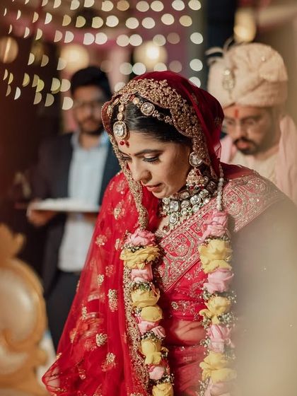 A candid, through-the-leaves shot of the bride during her wedding ceremony, creating a sense of intimacy and quiet observation.