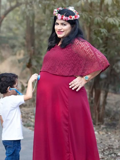 A fun and adorable maternity photo where a little boy pretends to be a doctor, listening to his mom's baby bump with a toy stethoscope.