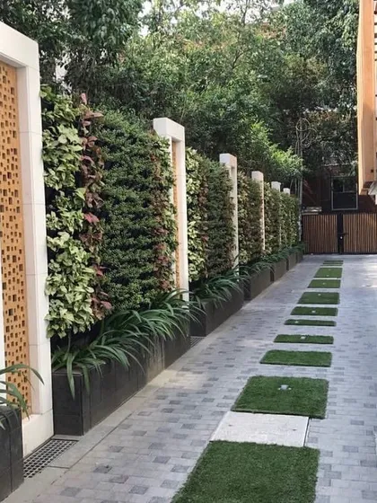 This driveway design combines function and beauty. I used vertical gardens to soften the long wall and interspersed grass pavers in the driveway to add a touch of green underfoot.