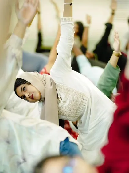 Participants in a corporate session engage in a full-body stretch. I guide groups through sequences that are accessible to all levels, ensuring everyone feels included and can experience the benefits of increased flexibility and energy.