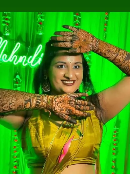 A powerful and happy pose from a bride, showcasing her full arm mehendi.