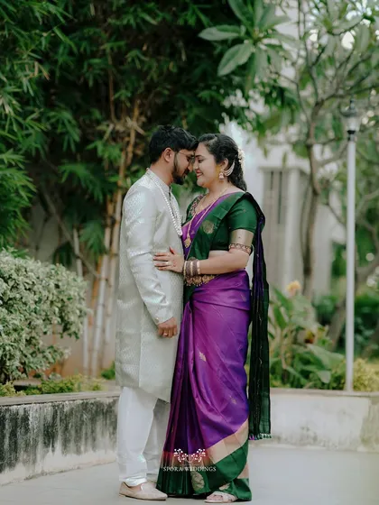 The couple sharing a quiet, intimate moment, their foreheads touching, in a beautiful garden setting.