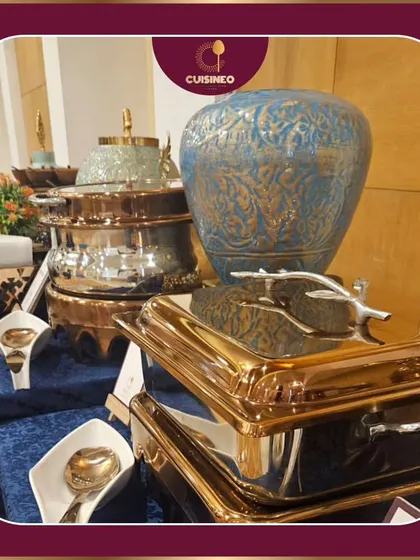 We use a variety of ornate and modern serving dishes, like these stunning blue and gold pieces, to match the theme and style of your event. It's about creating a visual feast that complements the culinary one.
