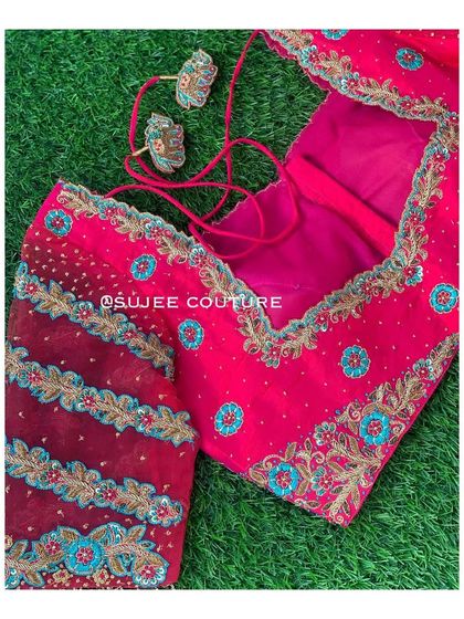 Another angle of the pink blouse with sheer sleeves, showing the included embroidered tassels that can be attached to the back closure.