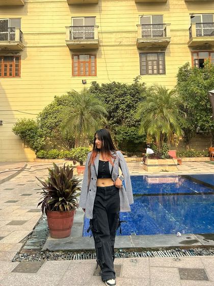 A side view of the blazer and cargo pants outfit. This highlights the unique silhouette of the cape-style blazer.