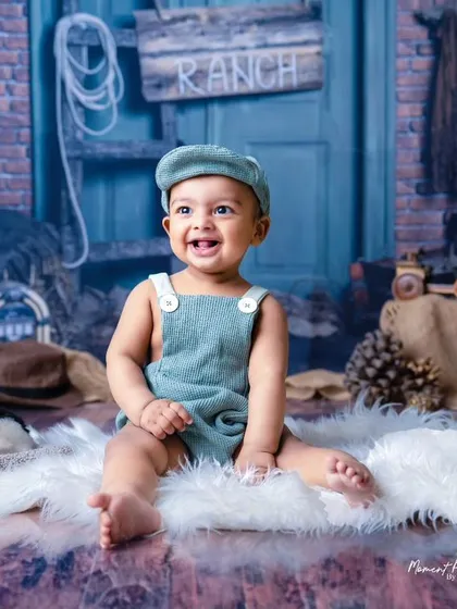 Delightfully cute in every frame. This baby boy's happy smile lights up this rustic ranch-themed milestone session.