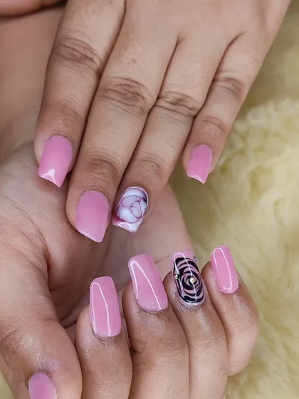 A full view of the pink manicure with detailed, hand-painted rose and marble art.