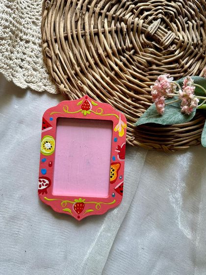 This pink frame magnet is decorated with a variety of colorful, tiny fruits.