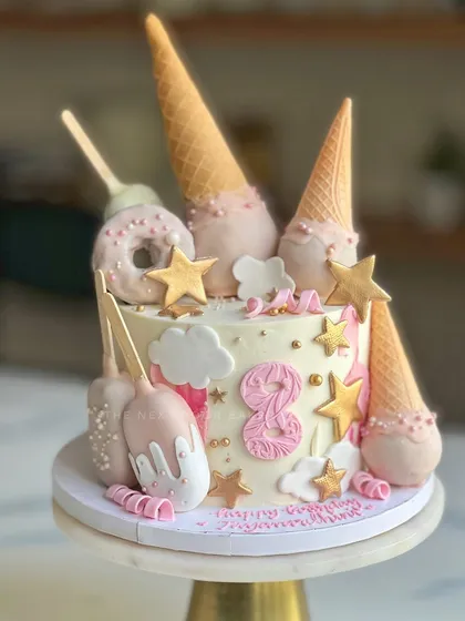All things pastel pink and candy for an 8th birthday celebration! This cake is loaded with fun treats like cakesicles, ice cream cones, and fondant stars, making it a dream come true for any kid with a sweet tooth.