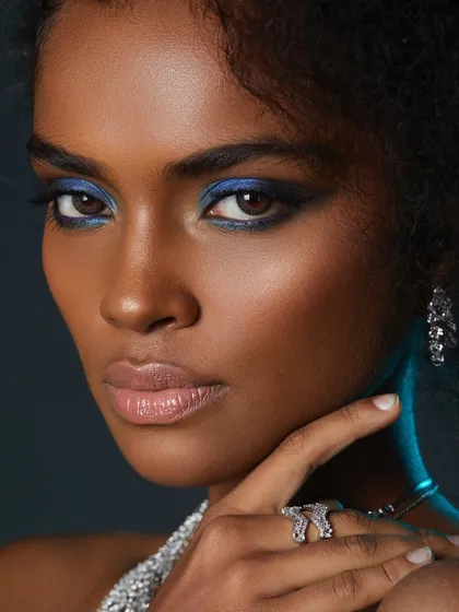 A close-up on the perfectly blended blue eyeshadow and flawless skin. This is the level of quality and precision we teach.