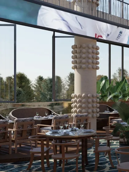 The dining area by the large windows offers guests a connection to the outdoors. The columns, adorned with spherical elements, are a modern interpretation of Tiki totems, adding a playful yet sculptural touch.