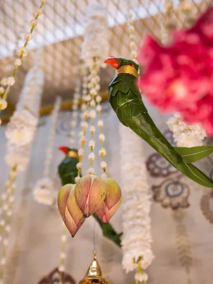 A close-up of the handcrafted parrot and lotus bud hangings. These small, artistic details, made from natural leaves and flowers, are what make our traditional decor setups so special and unique.