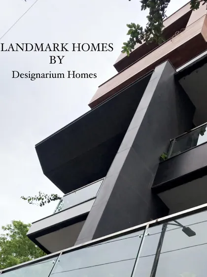 A corner detail of a recently completed modern residence, showcasing sharp, angular silhouettes and the juxtaposition of dark metal cladding with clear glass railings. This image captures our ability to translate bold architectural concepts into precisely executed structures.