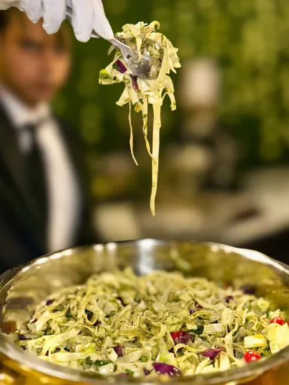 I offer a variety of noodle dishes to suit any palate. Here, a server presents a bowl of my Flat Noodles in Green Thai Sauce, a creamy, aromatic, and flavourful main course option for lovers of Thai food.