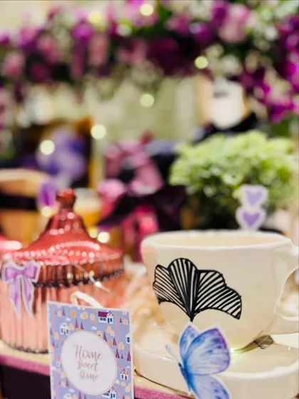 This detailed shot focuses on the elegant ginkgo leaf mug and a 'Home Sweet Home' card, emphasizing the cozy and personal nature of our housewarming gifts.