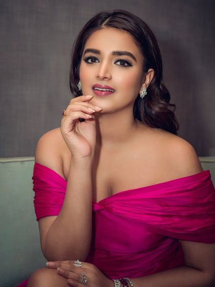 A full-length portrait of actress Nidhhi Agerwal in a stunning magenta gown. This shot was taken for an event, capturing her elegance and the dress's beautiful silhouette.