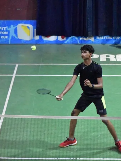 A young player poised at the net, ready to intercept the shuttle. Quick reflexes and net dominance are critical skills we develop.