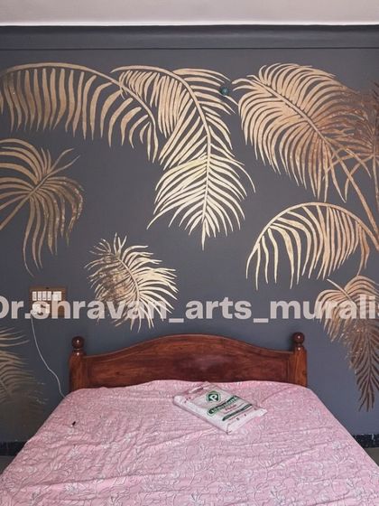 The classic look of gold foil palm leaves on a dark grey wall. This design adds a touch of tropical glamour to a bedroom, making the space feel both cozy and chic.