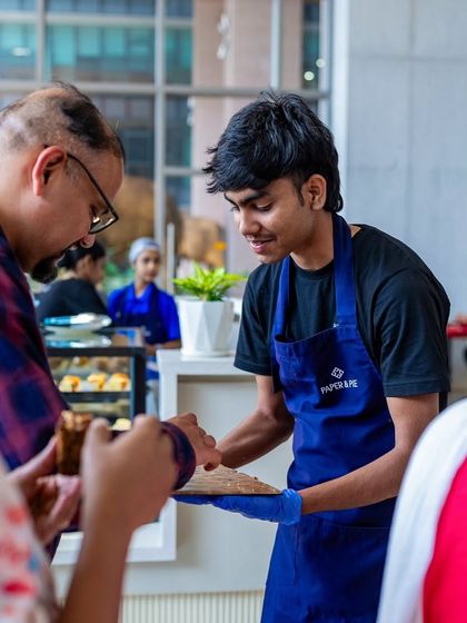 Our staff serving customers with a smile at the RMZ Ecoworld cafe. Hospitality is at the heart of what we do.