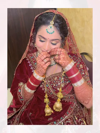 A candid shot of the bride adjusting her jewelry. The details of her velvet lehenga, chooda, and kalira are beautifully captured here.