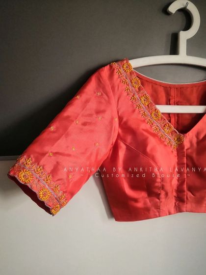 A detailed shot of the sleeve and neckline embroidery on the custom-made blouse.