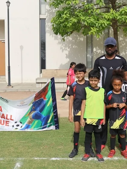 Our youngest league participants posing with their coach. We believe in starting early, building a foundation of skills and a love for football that lasts a lifetime.