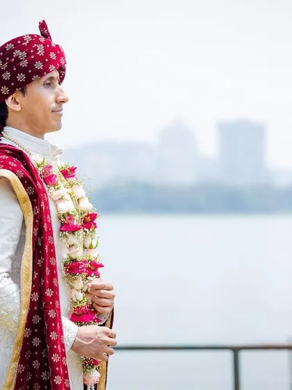A classic portrait of the groom in his wedding attire, with the city skyline in the background. A handsome and confident shot.