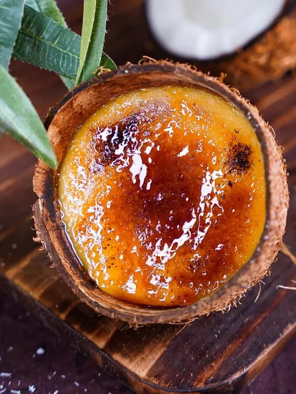 Our Crème Caramel served in a natural coconut shell. This classic dessert combines silky custard with a rich caramel sauce for a heavenly match.