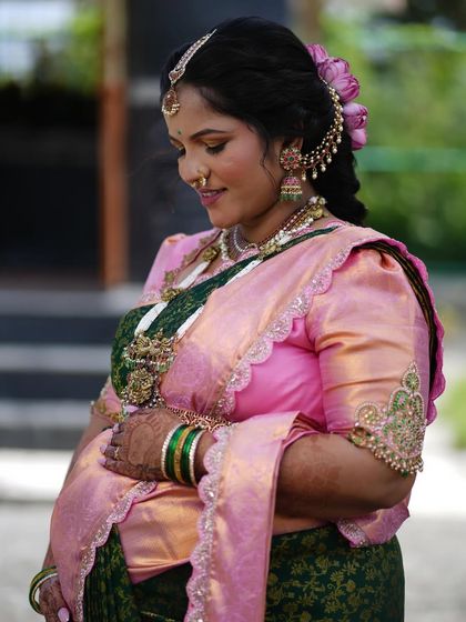 A side profile highlighting the hairstyle and the beautiful details of her earrings and nose ring.