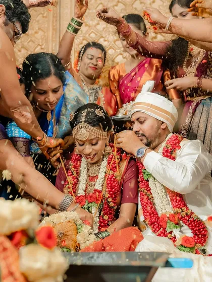 A candid shot of the couple surrounded by family during the 'Talambralu' rice showering ceremony, full of blessings and joy.