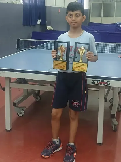 Young paddler Siddanth showcasing his two trophies after finishing as a Semi Finalist in both the U13 and U15 Boys categories at the Krida Station Open Junior Table Tennis Tournament.