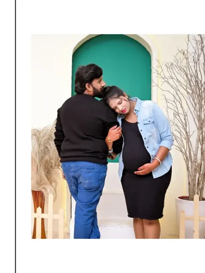 A quiet, intimate moment between a couple. The black and denim outfits give this shot a modern, casual feel, while the tender pose captures the deep emotional connection of their pregnancy journey.