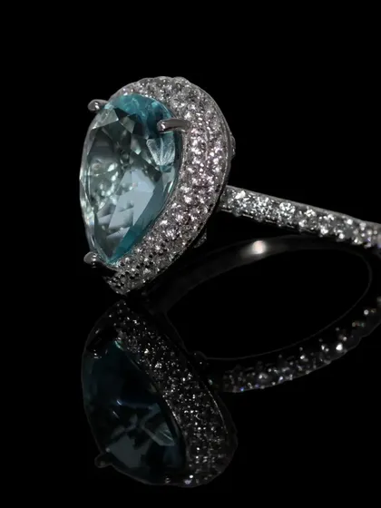 A true showstopper, this statement cocktail ring features a large, teardrop-shaped aquamarine-colored stone surrounded by a halo of sparkling zirconia. Crafted in pure 92.5 silver, it's designed for those special events where you want your jewelry to make an impact.