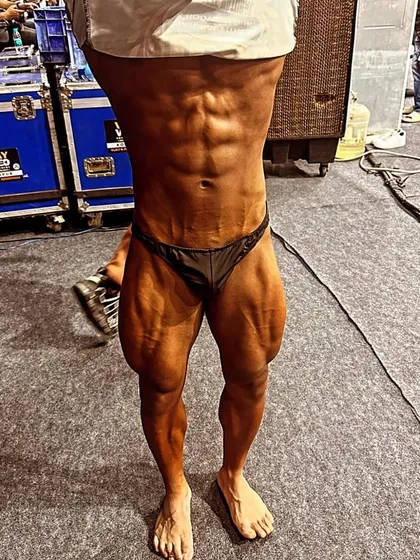 A close-up of the incredible abdominal and leg definition achieved during the 8-week prep. This is the level of conditioning required to win.