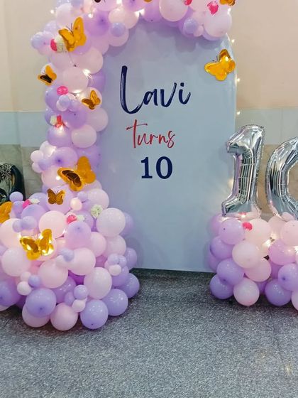 A sweet butterfly theme for a 10th birthday. I used a custom backdrop for "Lavi turns 10" and a balloon arrangement in shades of pink and lavender, with gold butterfly accents and large silver foil numbers.