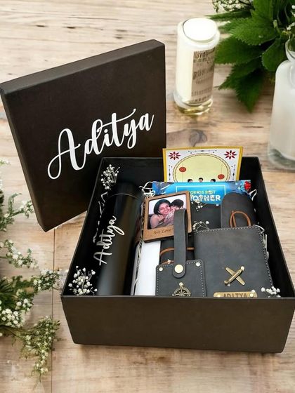 A beautifully curated and personalized gift box for 'Aditya'. This hamper is filled with custom items like a tumbler and leather accessories, complete with a personal photo.