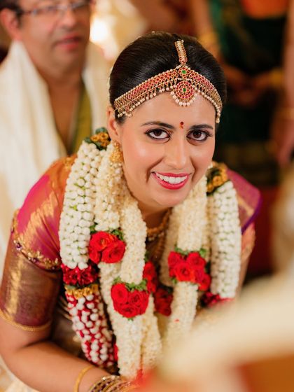 A close-up of her radiant smile, with a bold red lip that adds a touch of classic bridal glamour.