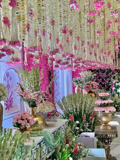 A stunning display of blooms and garlands, blending tradition with elegance. This composition of pink and white florals against a detailed backdrop creates the perfect welcome. 🪷