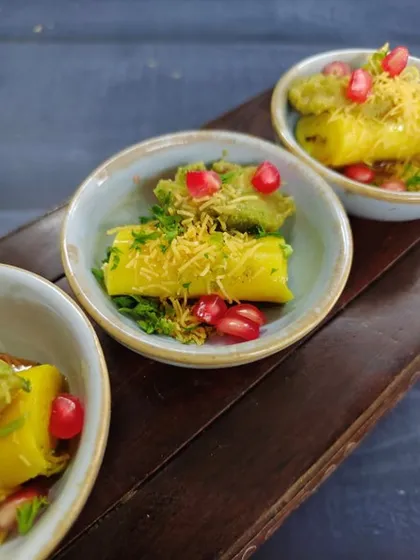 Golden swirls of Gujarat. Soft, melt-in-your-mouth Khandvi, rolled to perfection and topped with crunchy sev, fresh coriander, and juicy pops of pomegranate.