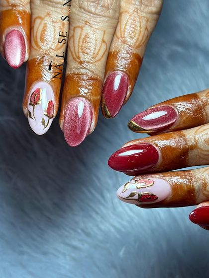 This angle highlights the glossy finish of the cat eye polish and the intricate details of the hand-painted roses.
