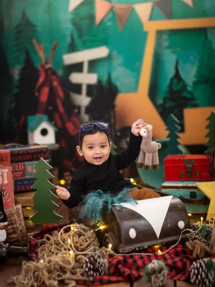 Having fun with a toy animal in our camper van prop. Interactive props help keep little ones engaged and happy during their session.